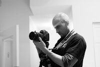 black and white photo of a man holding a camera