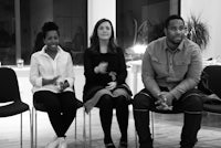 black and white photo of a group of people sitting in chairs