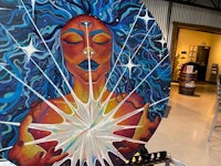 a painting of a woman with blue hair on a table