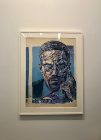 a painting of a man with glasses hanging on a wall