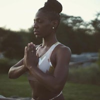 a woman in a bikini meditating outdoors