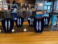 a group of black feather earrings on a table in front of a bar