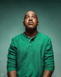 a man in a green shirt is looking up at the camera