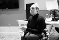 a woman sitting on a chair in front of a microphone