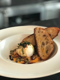 a white plate with a poached egg and bread