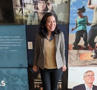 a woman standing in front of a wall of photos