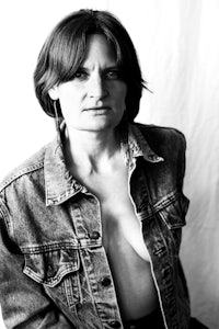 a black and white photo of a woman in a denim jacket