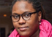 a black woman wearing glasses and a pink scarf