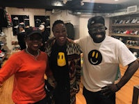 three people posing for a photo in a shoe store