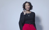 a woman wearing a black top and red pants